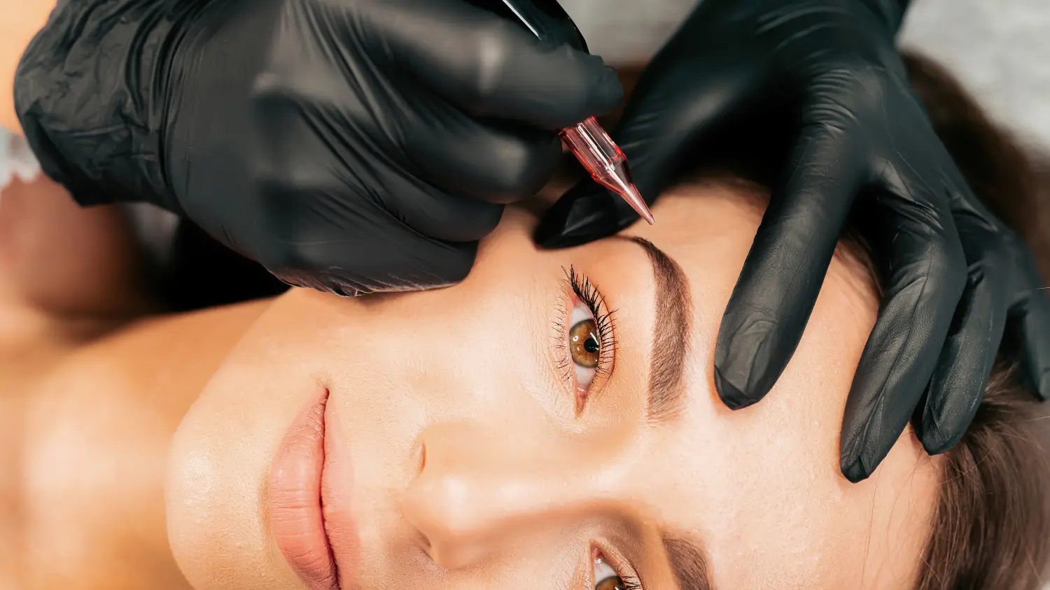 Der Make-up-Meister führt den Eingriff des permanenten Augenbrauen-Make-ups durch